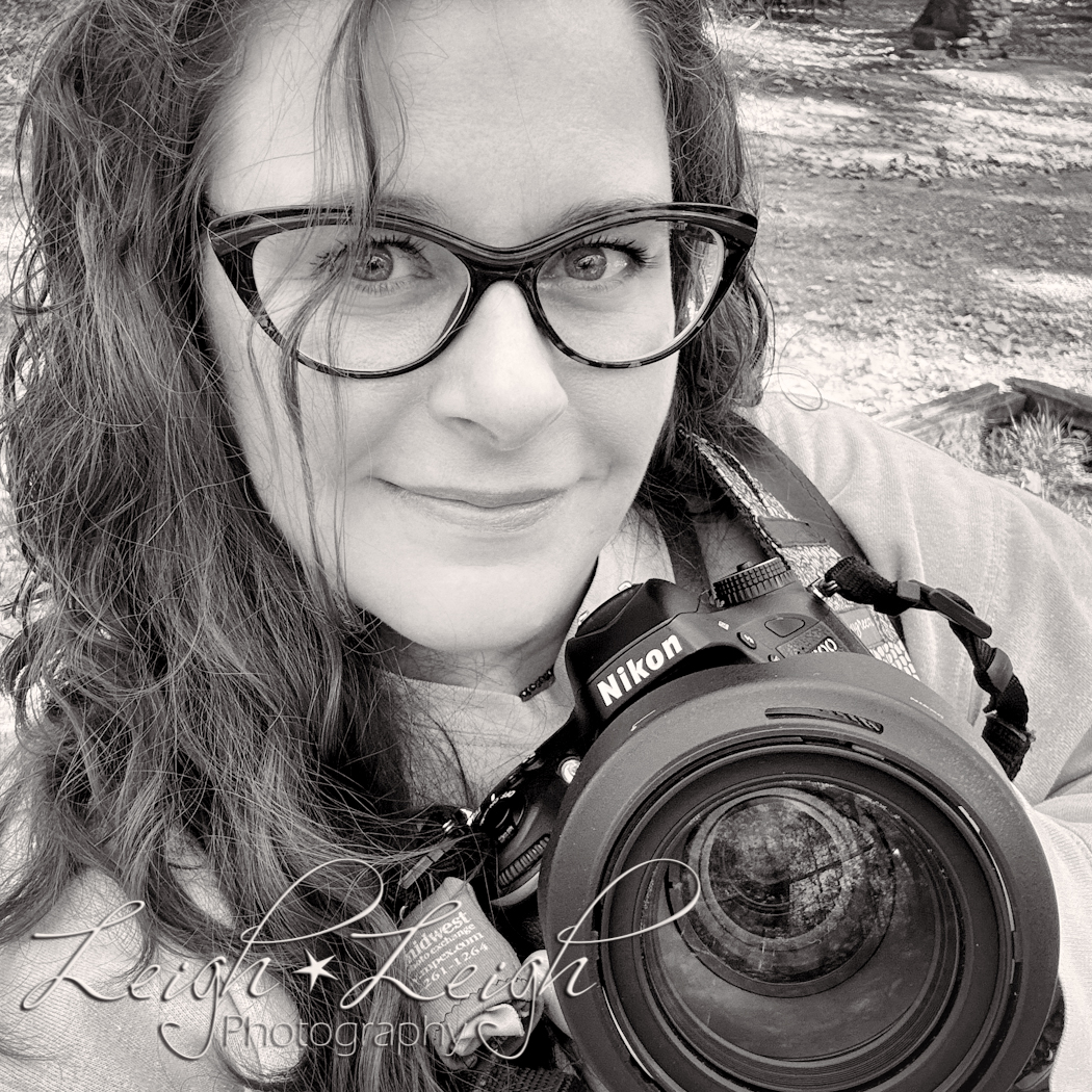 Black and white image of Rachel holding a Nikon camera